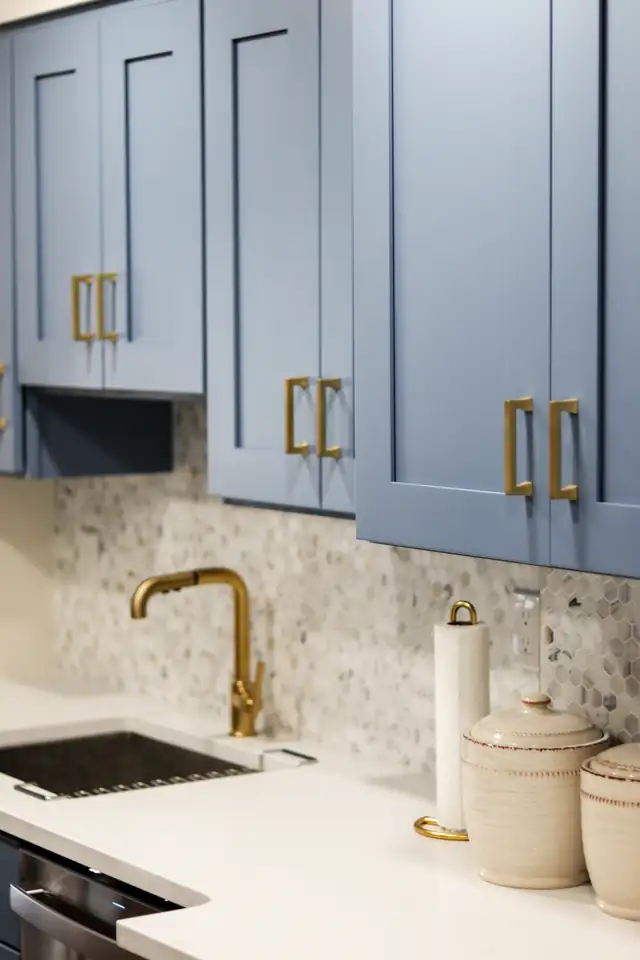 Hackensack kitchen by Hamlett Renovations with light blue shaker cabinets, brass pulls, a brass faucet and marble hexagon backsplash