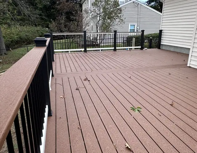 New composite deck with black metal railing in a North Jersey backyard