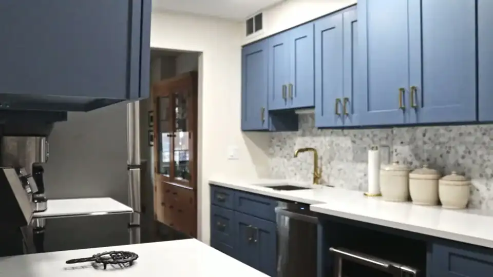 Kitchen remodeling near Wayne, NJ: Hackensack kitchen with blue Shaker cabinets, white marble hexagon backsplash and brass faucet