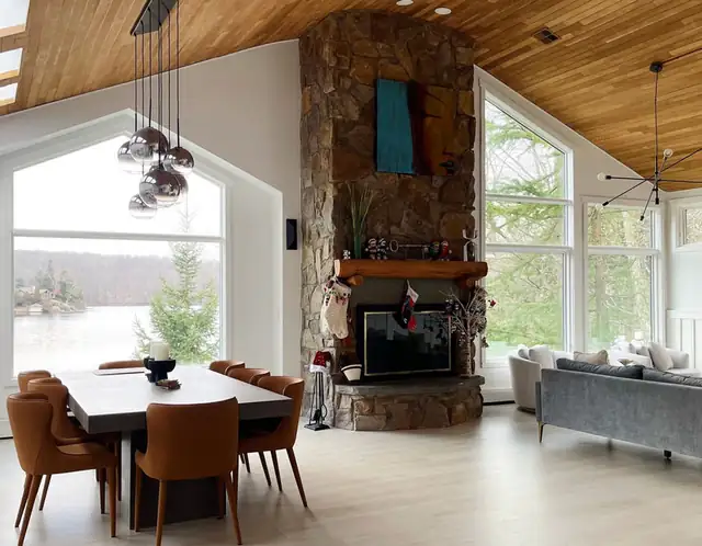 Home addition great room in North Jersey with wood plank ceiling, stone fireplace and tall windows