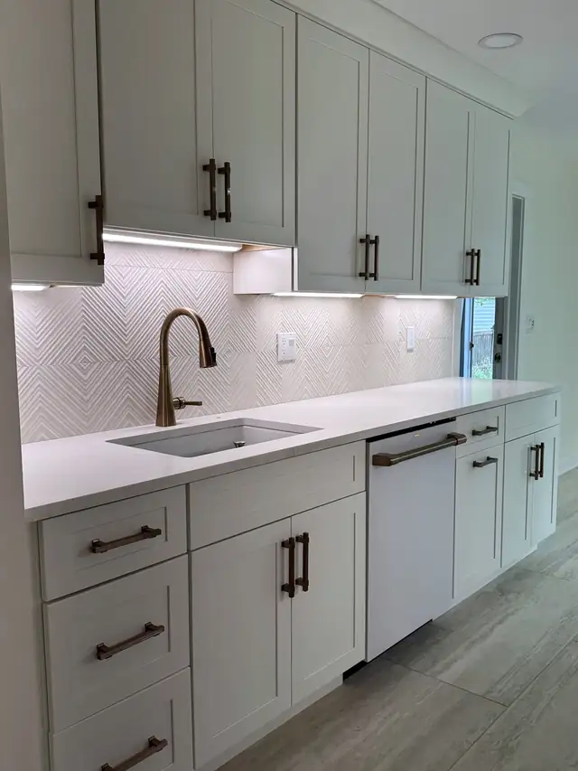 Finished galley kitchen in Montclair, NJ with white Shaker cabinets and quartz countertops